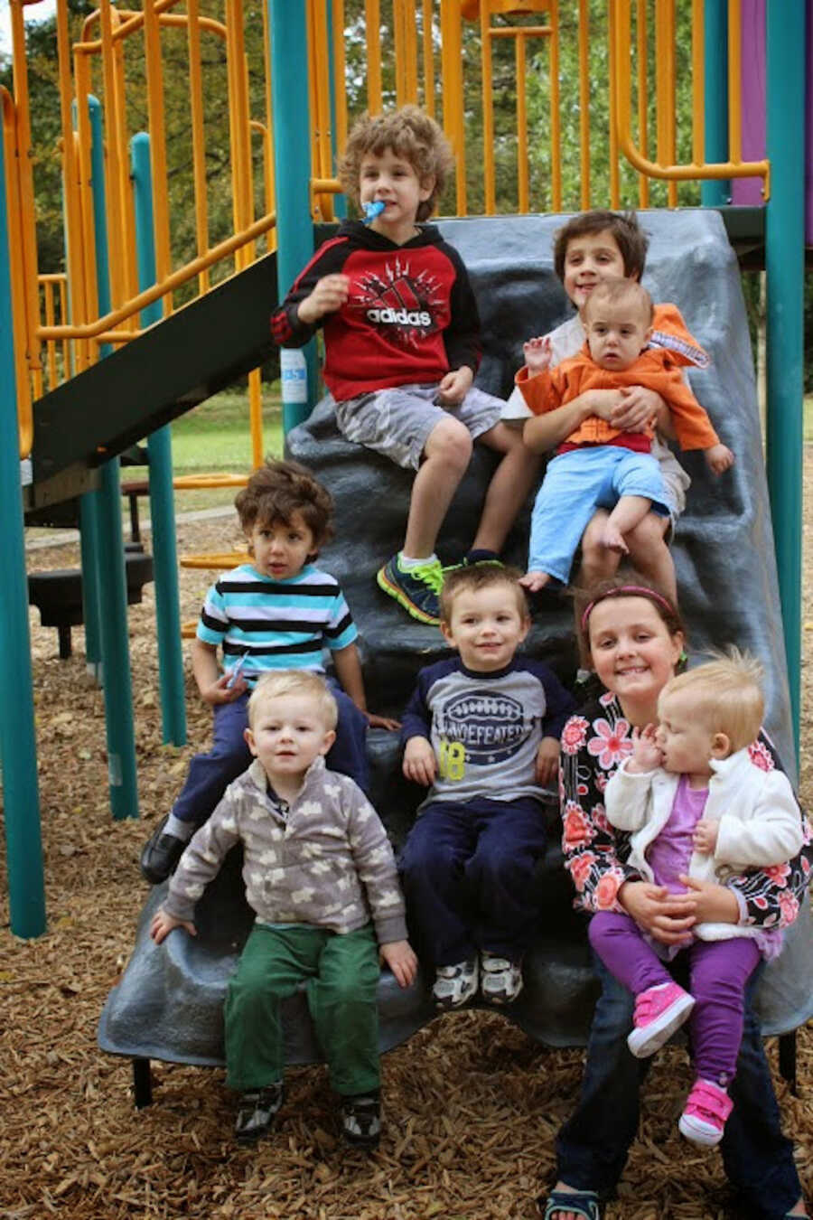 biological and adopted siblings sitting together on the playground