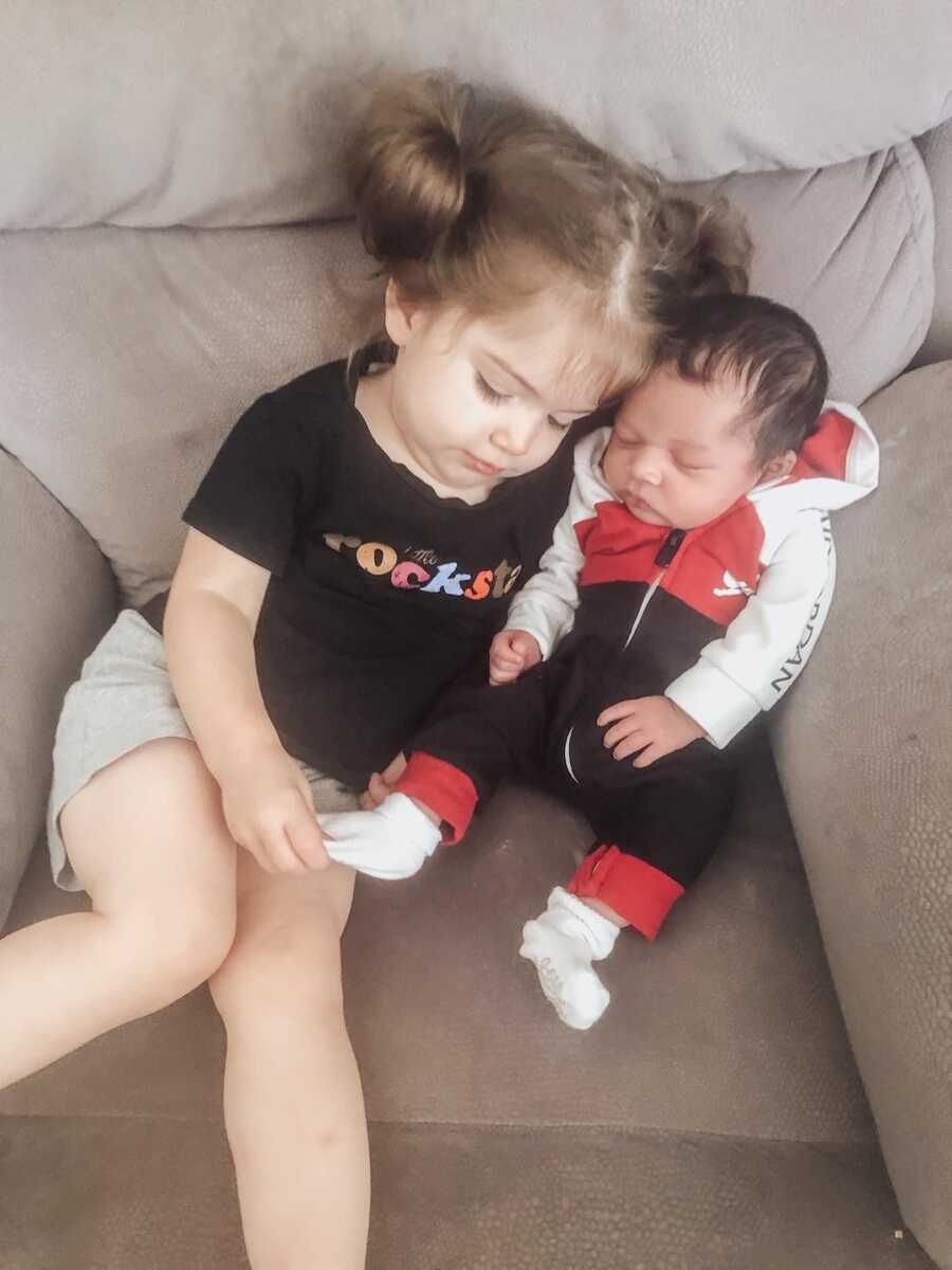 foster siblings sit on chair together