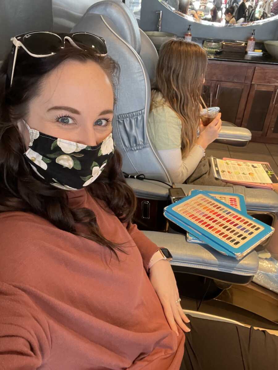 stepdaughter sitting with her stepmom while they get pedicures together