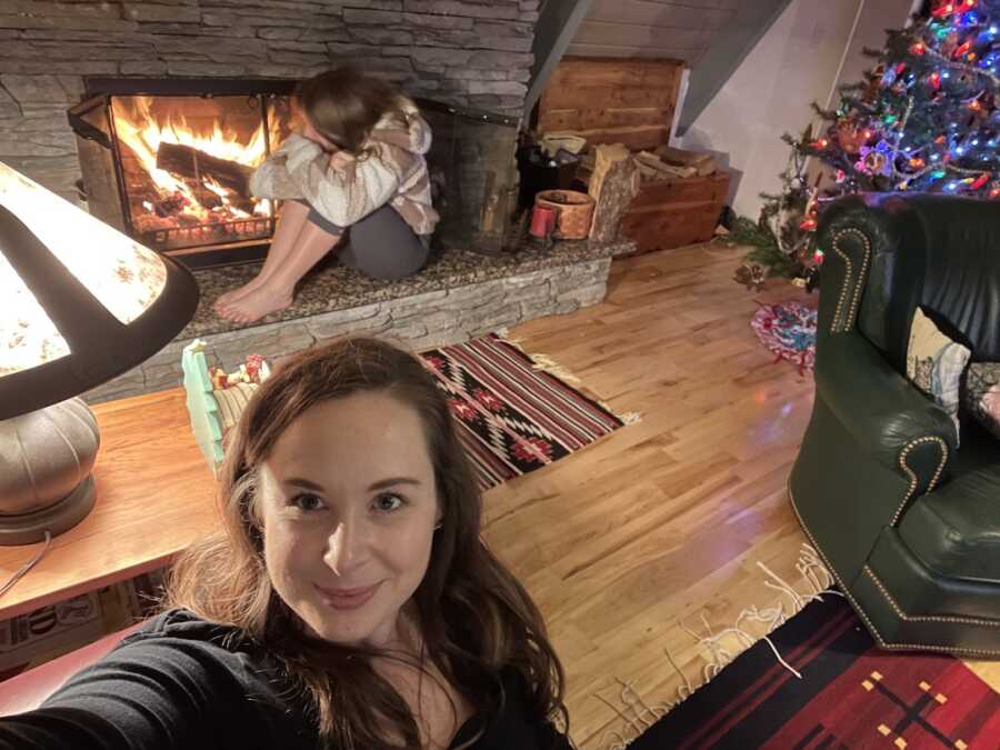 stepmom sitting with her stepdaughter by the fireplace