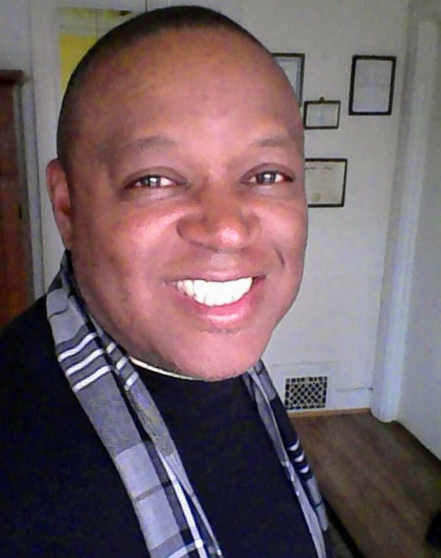 stroke survivor smiles in black shirt and grey scarf