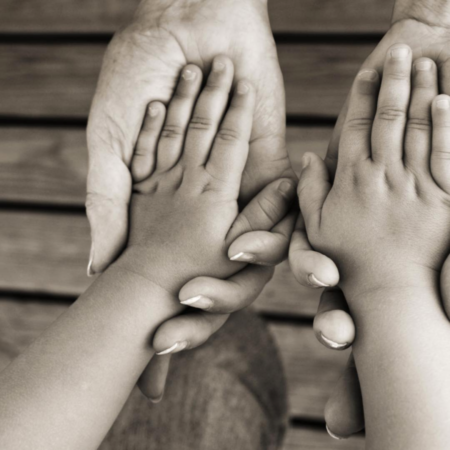 close up of mothers hands holding daughters hands 