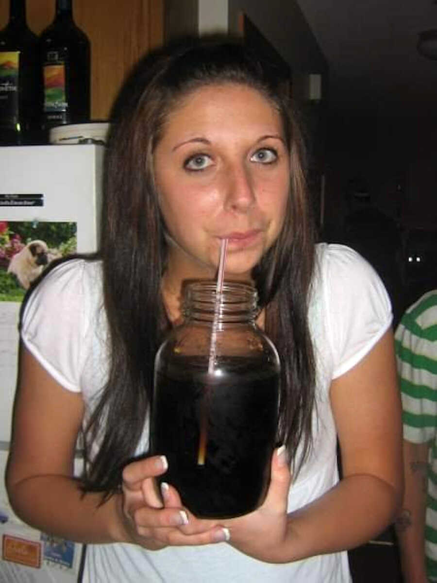 girl in college drinking alcohol out of a large mason jar