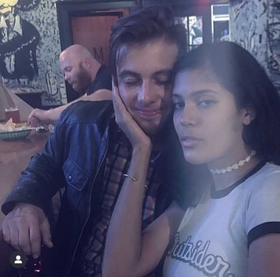 woman puts her hand on face of man while at bar