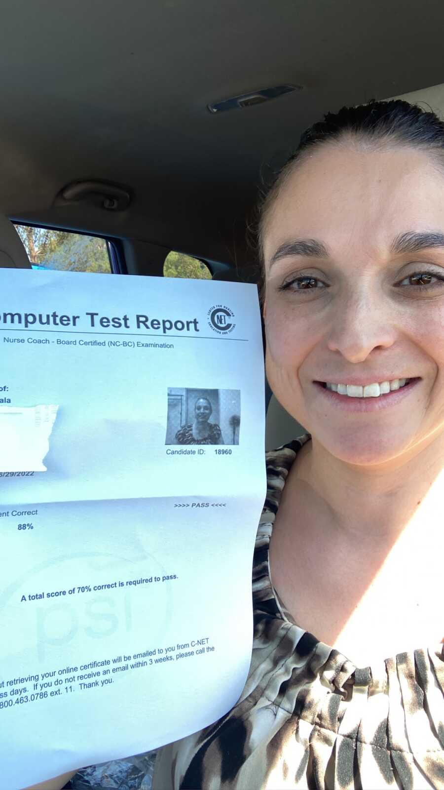 woman takes selfie holding her nurses certificate in hand