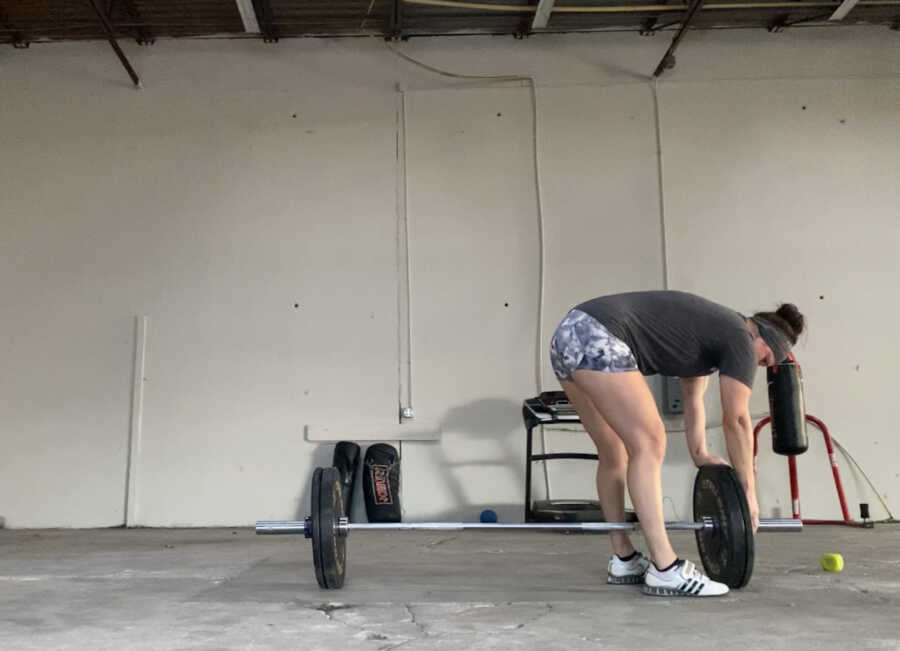 woman putting weight on bar in gym