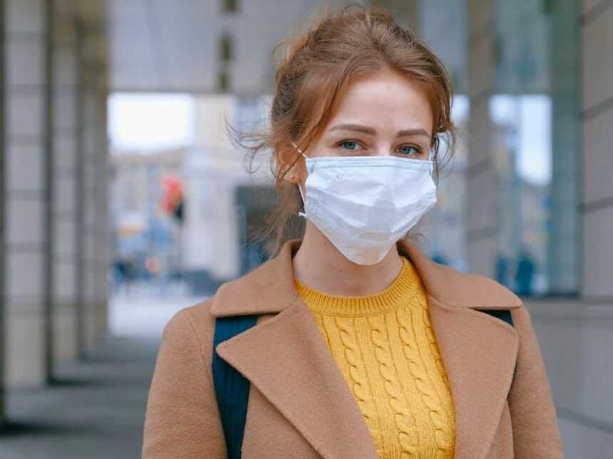 Woman wearing white face mask over mouth and nose