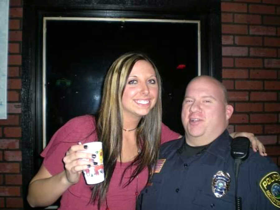 girl in college drinking while standing with a cop
