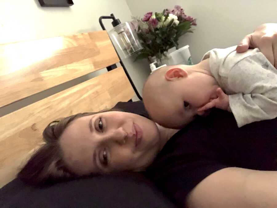 woman with lyme disease laying in bed with daughter on her chest