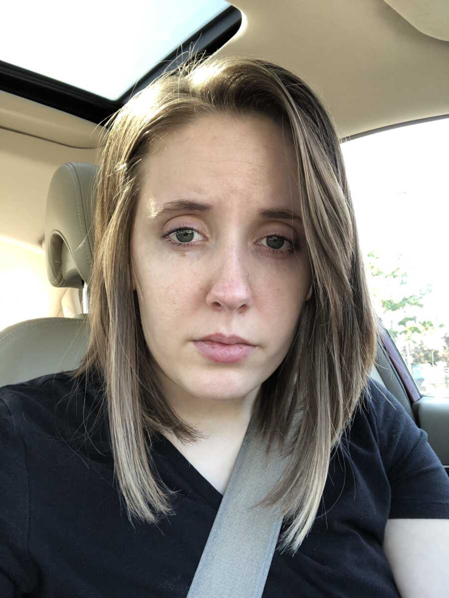 woman with lyme takes car selfie, looking sad