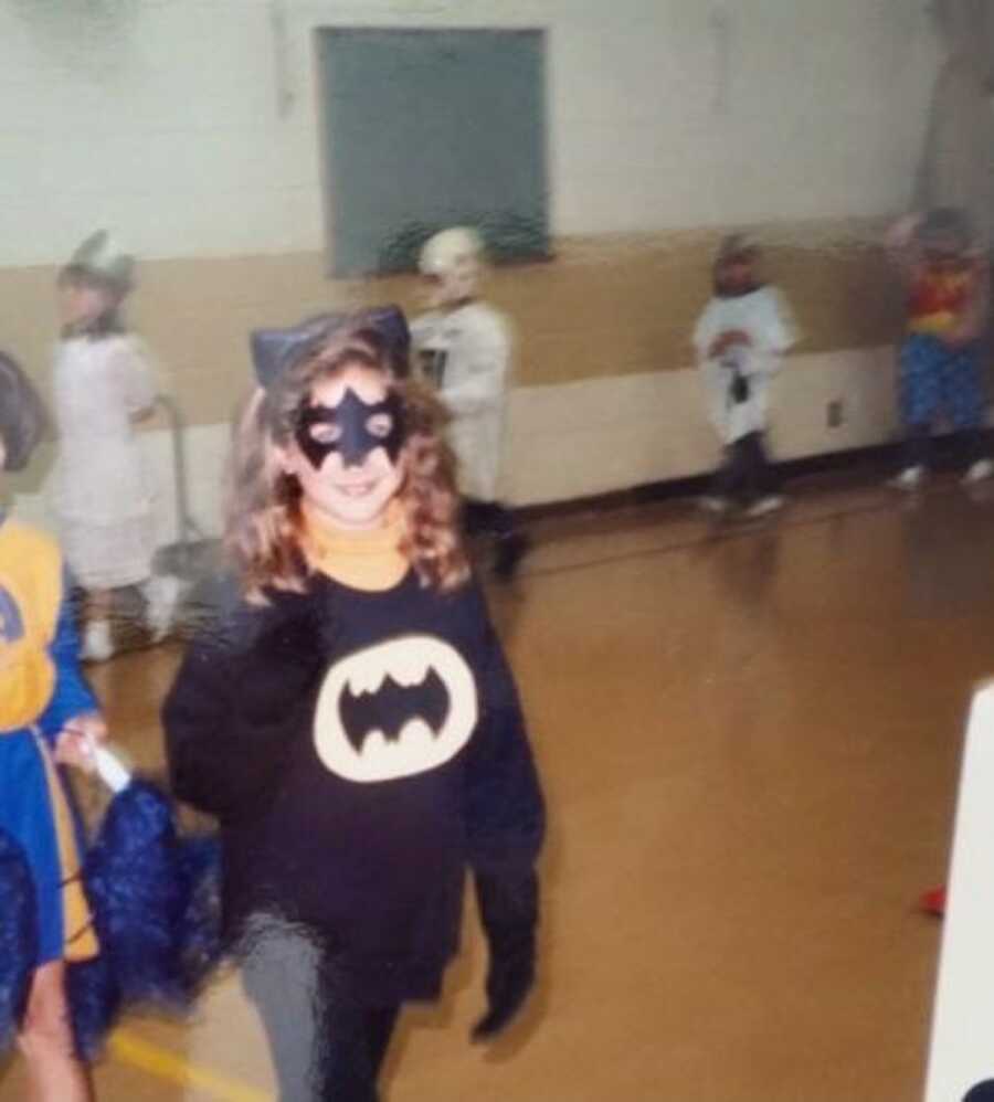 Young girl dressed up in a bat-woman costume for Halloween