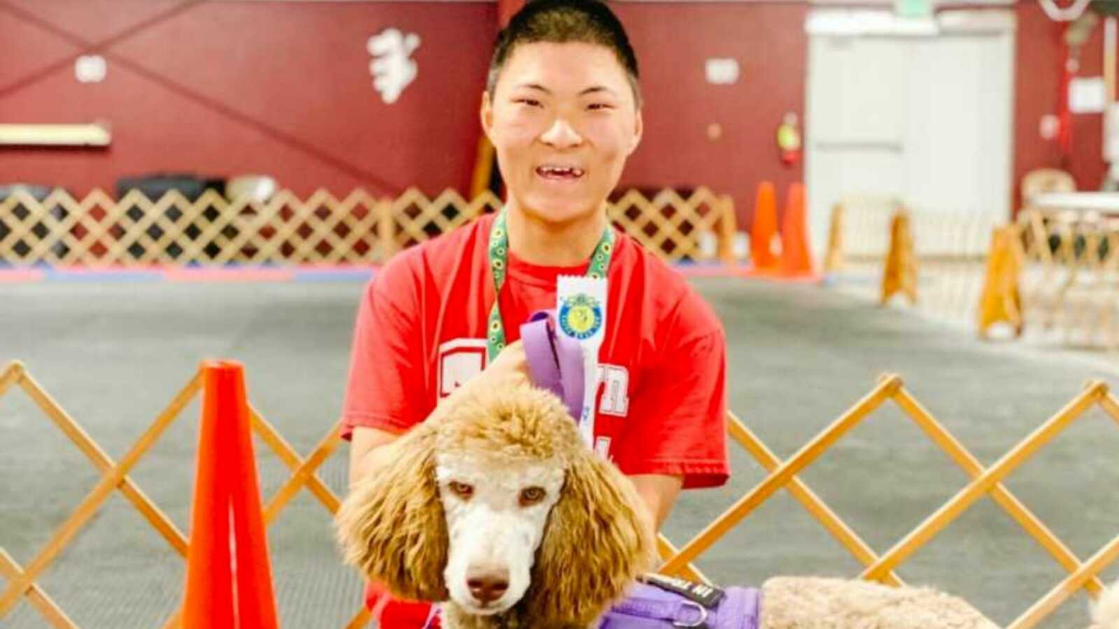 Teen with fetal alcohol spectrum disorder smiles with service dog