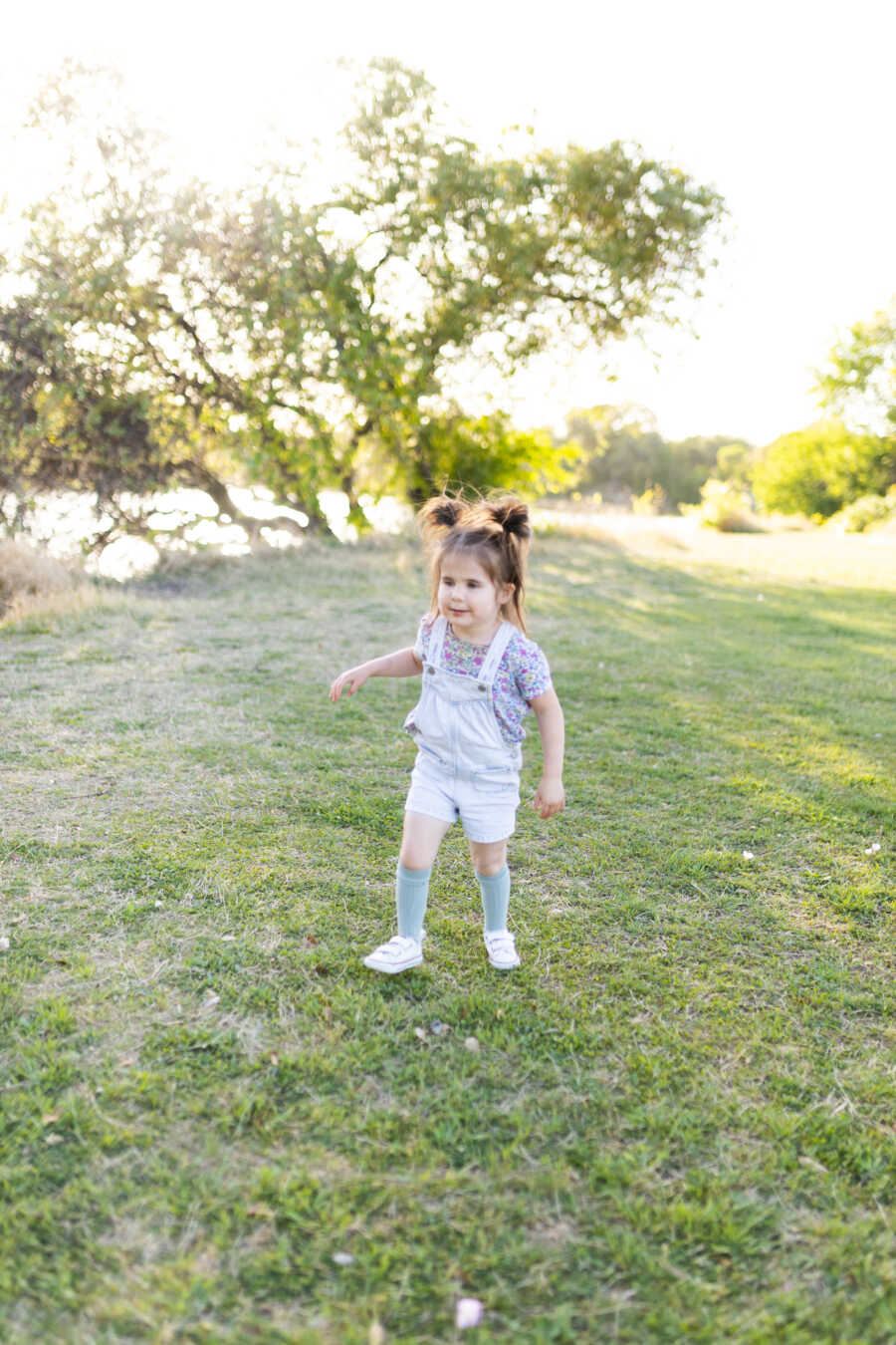 Young girl with genetic disorder walks through a field 