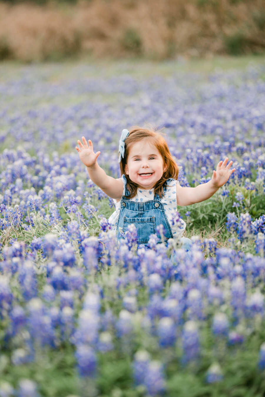 Toddler with rare genetic disorder sits in lavender field smiling